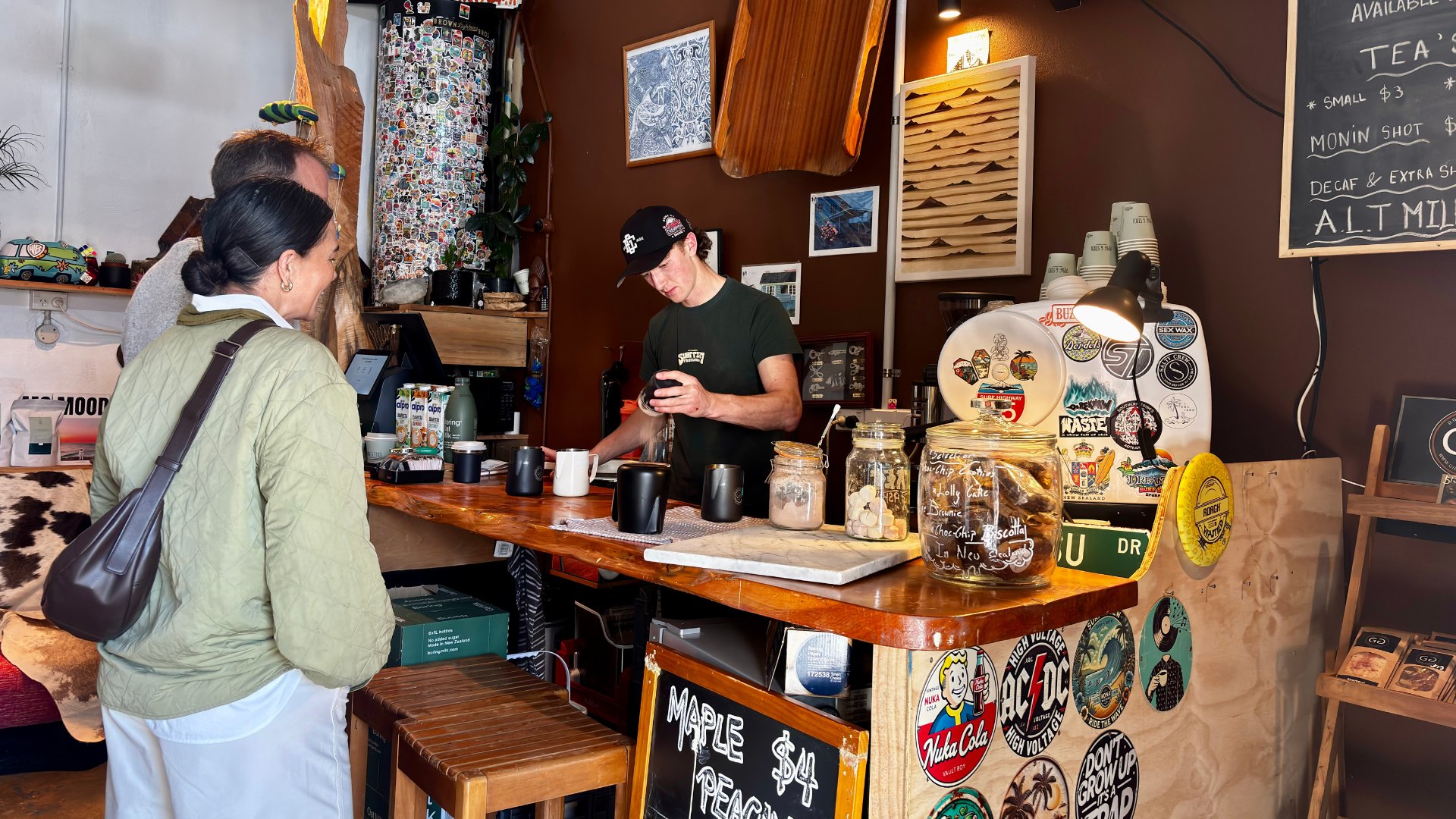 A customer being served coffee at the counter of a Taranaki cafe